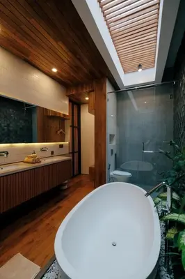 a bathroom with a tub and a toilet and a sink at Anama Villa Kerobokan in Seminyak
