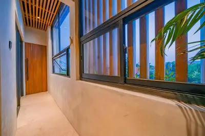 an empty hallway with windows and a palm tree at Villa Cek Ombak 2 Canggu in Canggu
