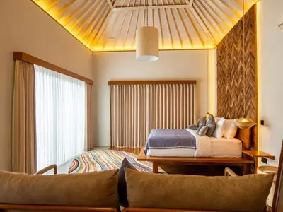 a bedroom with a bed and a couch at tuluscolivingseminyakvilla2 in Seminyak