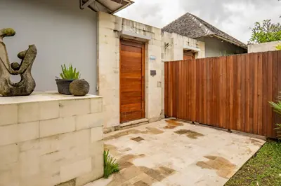 a house with a wooden gate and a patio at tuluscolivingseminyakvilla2 in Seminyak