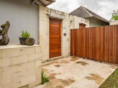 a house with a wooden gate and a patio at tuluscolivingseminyakvilla3 in Seminyak