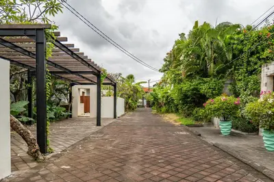 a brick walkway with a pergola and plants at tuluscolivingseminyakvilla3 in Seminyak