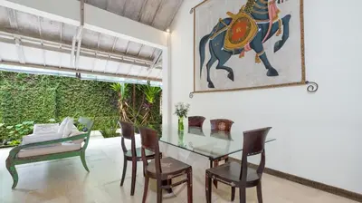 a dining room with a glass table and chairs at Gembira Villa Seminyak in Canggu
