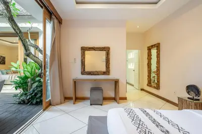 a bedroom with a table and a mirror at Le Chloe Villa Seminyak in Seminyak