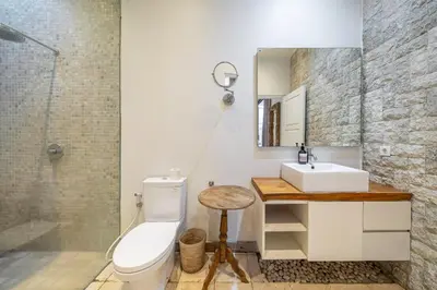 a bathroom with a sink and a toilet and a mirror at Le Chloe Villa Seminyak in Seminyak