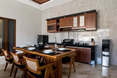 a kitchen with a large wooden table and chairs at Villa Sakura III Seminyak in Seminyak