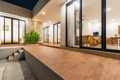 a living room with a wooden floor and windows at Villa Litan Seminyak - 3 Bedroom Villa in Seminyak