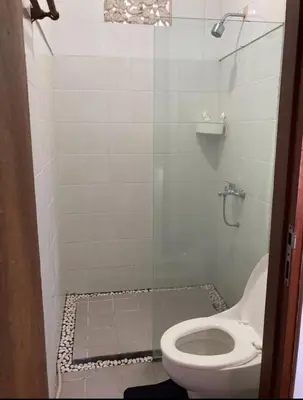 a bathroom with a toilet and a glass shower at RBE Hotel Kuta 2- 5 Min to Airport&Beach by Micky Studio in Ngurah Rai International Airport