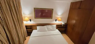 a small bed in a hotel room with two lamps at The Palmana Courtyard Jayakarta Residence 4 in Seminyak