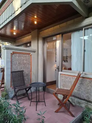a patio with two chairs and a table on a house at The Palmana Courtyard Jayakarta Residence 6 in Seminyak