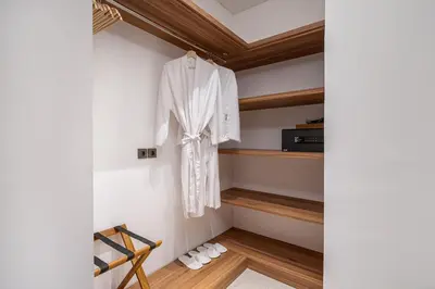 a walk in closet with a white robe hanging on a wall at Incredible Family villa with water slide Beachside in Sanur