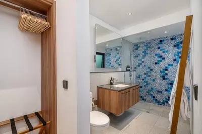 a bathroom with a sink and a toilet and a mirror at Incredible Family villa with water slide Beachside in Sanur