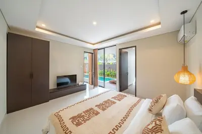 a bedroom with a large bed and a television at Modern 3BR Villa Private Pool Serangan Beach in Pulau Serangan