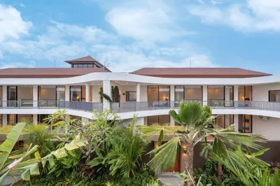 an exterior view of a building with palm trees at Modern 3BR Villa Private Pool Serangan Beach in Pulau Serangan