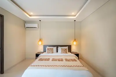 a bedroom with a bed and two lights at Modern 3BR Villa Private Pool Serangan Beach in Pulau Serangan