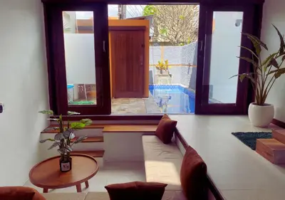 a living room with a couch and a table at Villa Casanomi By Pandara in Kerobokan