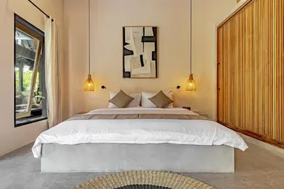 a bedroom with a large bed and a window at Villa Surga Kecil Seminyak in Seminyak