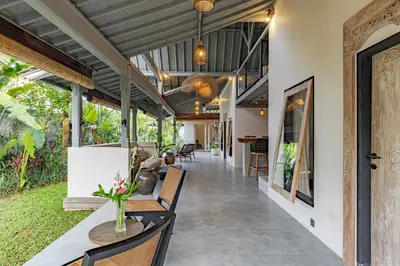 an open hallway of a house with a table and chairs at Villa Surga Kecil Seminyak in Seminyak