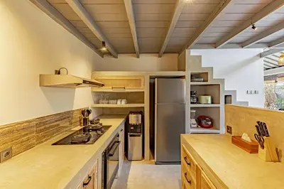 a kitchen with wooden counters and a stainless steel refrigerator at Villa Surga Kecil Seminyak in Seminyak