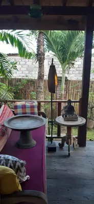 a living room with two tables and a palm tree at Desa Biasa in Kerobokan