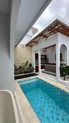 a swimming pool in the middle of a house at Maithala Villa & Living in Kuta