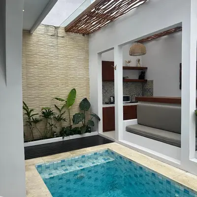 a swimming pool in the middle of a house at Maithala Villa & Living in Kuta