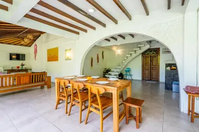 a dining room with a wooden table and chairs at Bali Dream Villa Legian by iBali Management in Seminyak