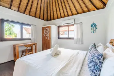 a bedroom with a white bed with a wooden ceiling at Bali Dream Villa Legian by iBali Management in Seminyak