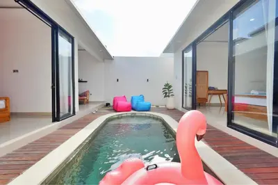 an indoor swimming pool with a pink flamingo in a house at Robelle Villa by iBali Management in Seminyak