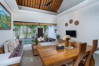 a living room with a table and a couch at Honeymoon Villa Aisha in The Heart of Legian in Seminyak