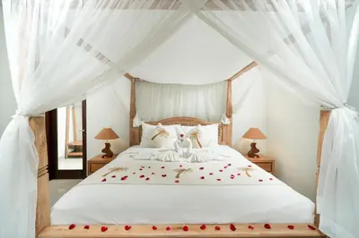 a bedroom with a canopy bed with roses on it at Honeymoon Villa Aisha in The Heart of Legian in Seminyak