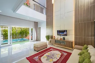 a living room with a couch and a tv at Casa Raya 4BR Villa in Kuta in Kuta