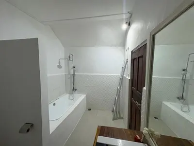 a white bathroom with a tub and a sink at Villa central seminyak in Seminyak