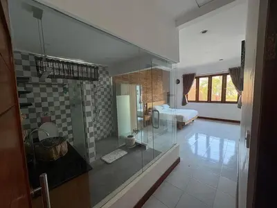 a bathroom with a glass shower and a bedroom at Villa central seminyak in Seminyak