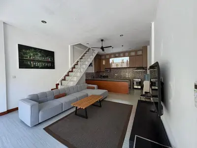 a living room with a couch and a kitchen at Villa central seminyak in Seminyak