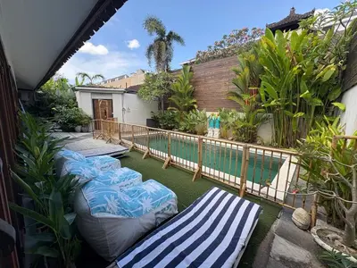 a patio with lounge chairs and a swimming pool at Villa central seminyak in Seminyak