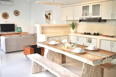 a living room with a wooden table in a kitchen at Villa 2BR Seminyak 8mins Beach in Seminyak