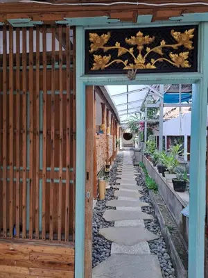 an entrance to a garden with a wooden gate at Lavender Villa 7 Moon House in Kuta
