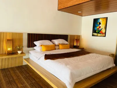 a bedroom with a large white bed with yellow pillows at Arden Loft in Kerobokan