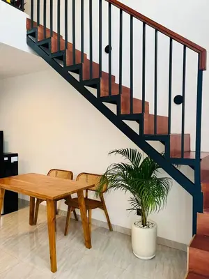 a staircase with a wooden table and a potted plant at Arden Loft in Kerobokan