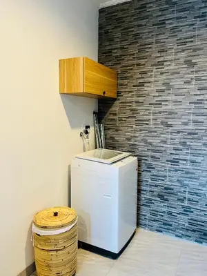 a small white refrigerator in a room with a brick wall at Arden Loft in Kerobokan