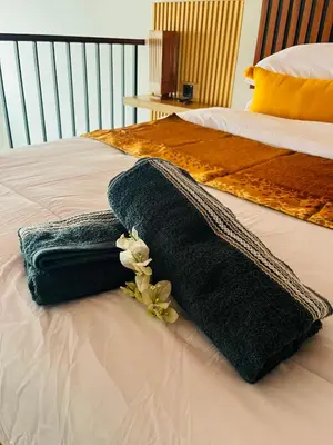 a black towel on a bed with flowers on it at Arden Loft in Kerobokan