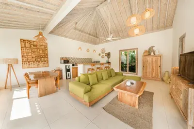 a living room with a green couch and a table at Villa Anna Lou 1BR Boho Escape in Seminyak in Seminyak