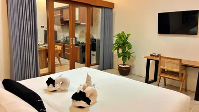 two cats in towels on a bed in a room at Villa Sakura Nisa in Seminyak
