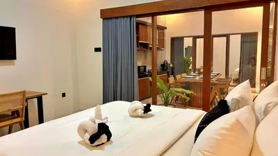 three cats laying on a bed in a room at Villa Sakura Nisa in Seminyak