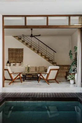 a house with a swimming pool and a living room at Villa Casa Rumi in Canggu