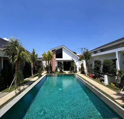 a swimming pool in front of a house at Kubumanik Loft in Seminyak