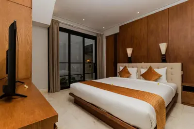 a bedroom with a bed and a flat screen tv at Villa By The Sea with private swimming pool in Benoa - Nusa Dua in Ujung