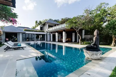 a pool with a statue in front of a house at Villa By The Sea with private swimming pool in Benoa - Nusa Dua in Ujung
