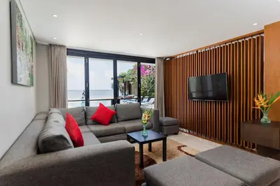 a living room with a couch and a television at Villa By The Sea with private swimming pool in Benoa - Nusa Dua in Ujung